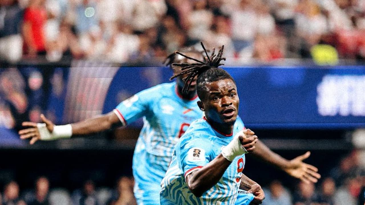 Brian Cipenga, joueur des Léopards de la RDC en maillot bleu ciel, court bras écartés pour célébrer son but contre l'Angleterre au Mondial 2026