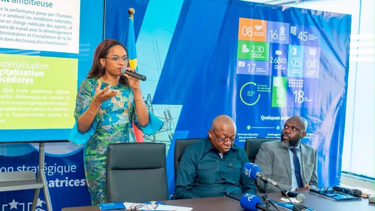 Soraya Aziz-Moto, directrice générale de l'ARE, s'exprime au micro lors du briefing des 100 jours, devant le logo de l'Autorité de régulation du secteur de l'électricité et un tableau de bilan affichant 2,30 milliards USD d'investissements et 45 projets énergétiques.
