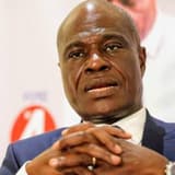 Martin Fayulu, président de l'ECiDé, les mains jointes devant un panneau aux couleurs de son parti lors d'une prise de parole publique