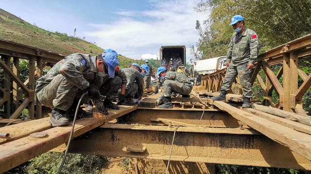 Des ouvriers et des engins reparent un pont routier en Republique democratique du Congo.