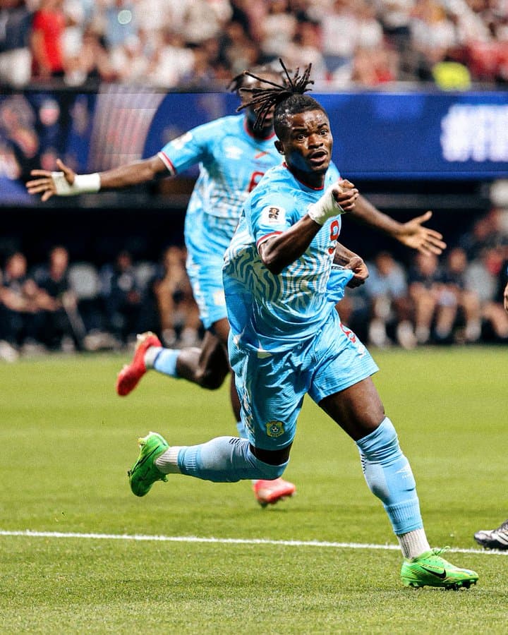 Brian Cipenga, joueur des Léopards de la RDC en maillot bleu ciel, court bras écartés pour célébrer son but contre l'Angleterre au Mondial 2026
