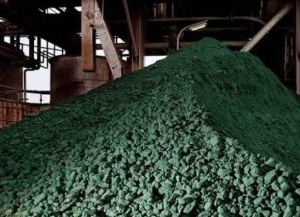 Un immense tas d'hydroxyde de cobalt vert entassé sous les passerelles métalliques d'une usine de traitement minier en République démocratique du Congo