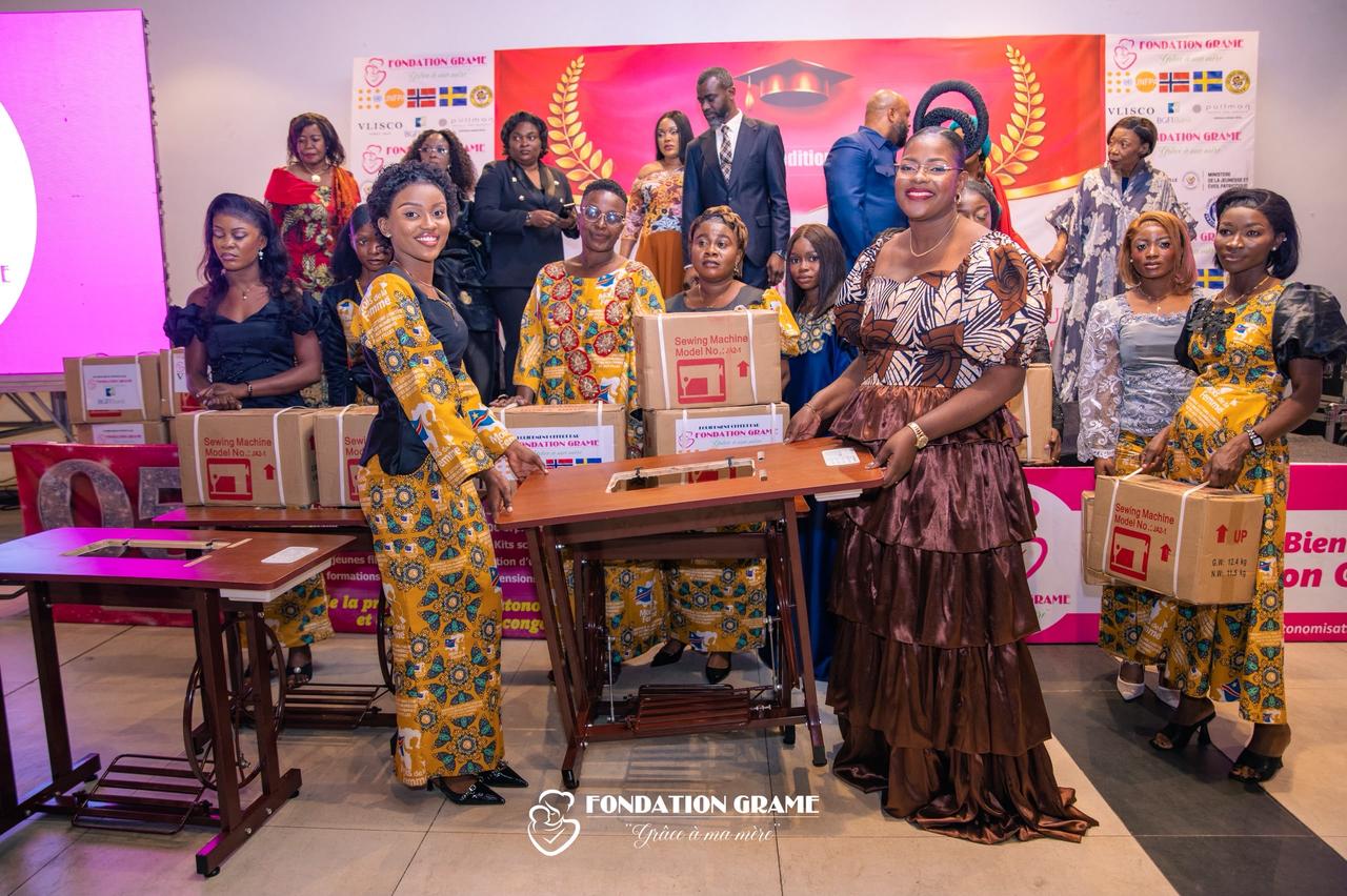 Des jeunes femmes formées par la Fondation GRAME posent avec leurs kits d'installation ,  machines à coudre et matériel de métier ,  lors de la cérémonie de remise à Kinshasa.