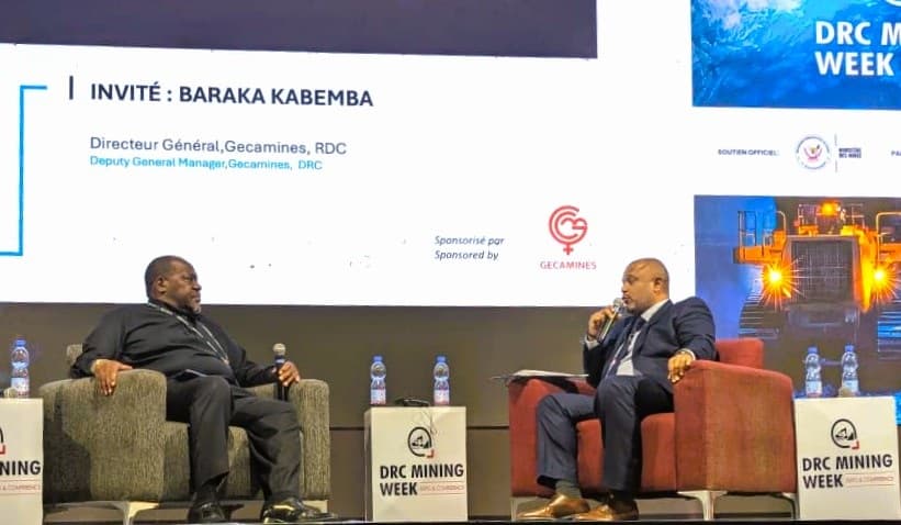 Baraka Kabemba, directeur général de la Gécamines, s'exprime au micro sur la scène d'un panel de la DRC Mining Week 2026, devant un écran affichant son nom et le logo de la Gécamines