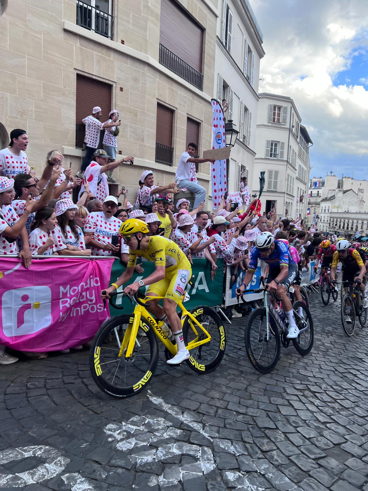 Tadej Pogačar en maillot jaune, penché sur son vélo dans la montée de la rue Lepic à Montmartre, devant Mathieu van der Poel, lors de la 21e étape du Tour de France 2026 à Paris.